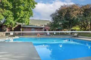 Una piscina al aire libre de temporada, sombrillas