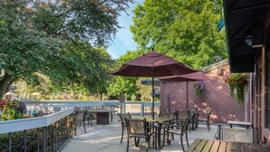 An outdoor patio with a table and chairs, surrounded by a railing and trees. - Best Western Sunridge Inn & Conference Center (Baker City)