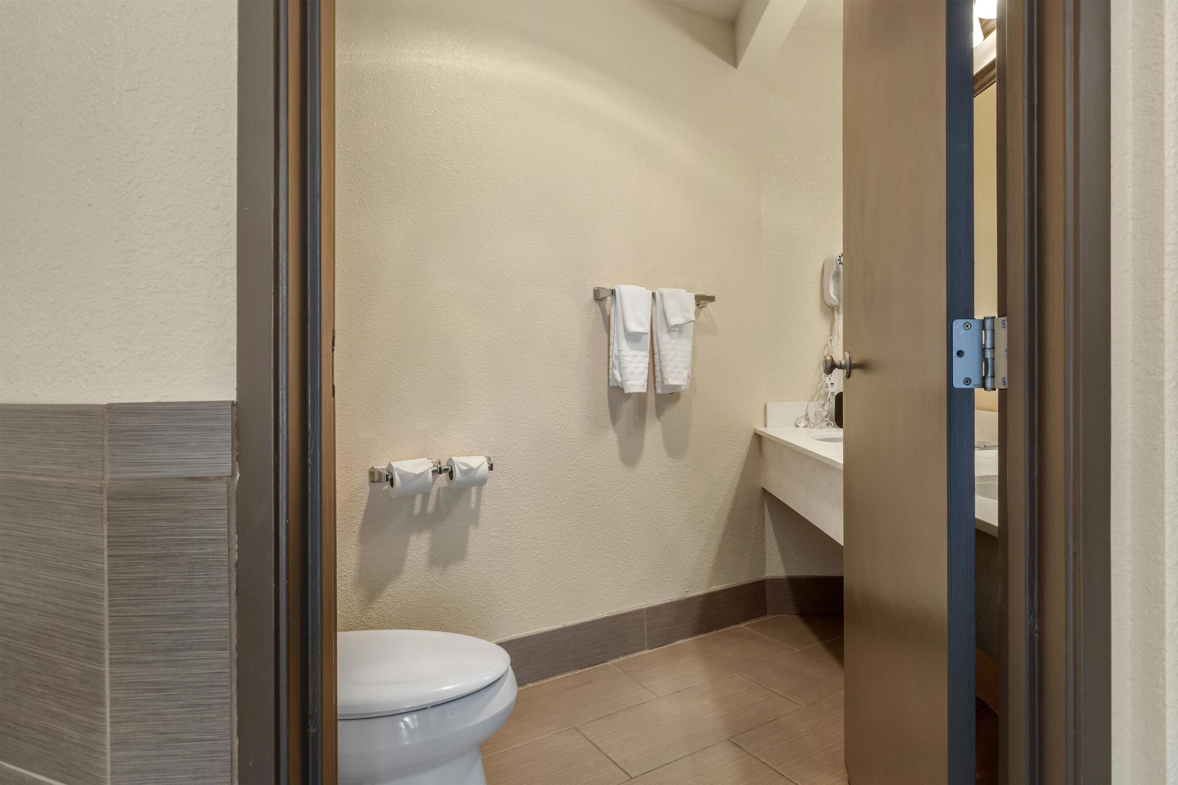 A bathroom with a toilet, towel rack, and sink.
