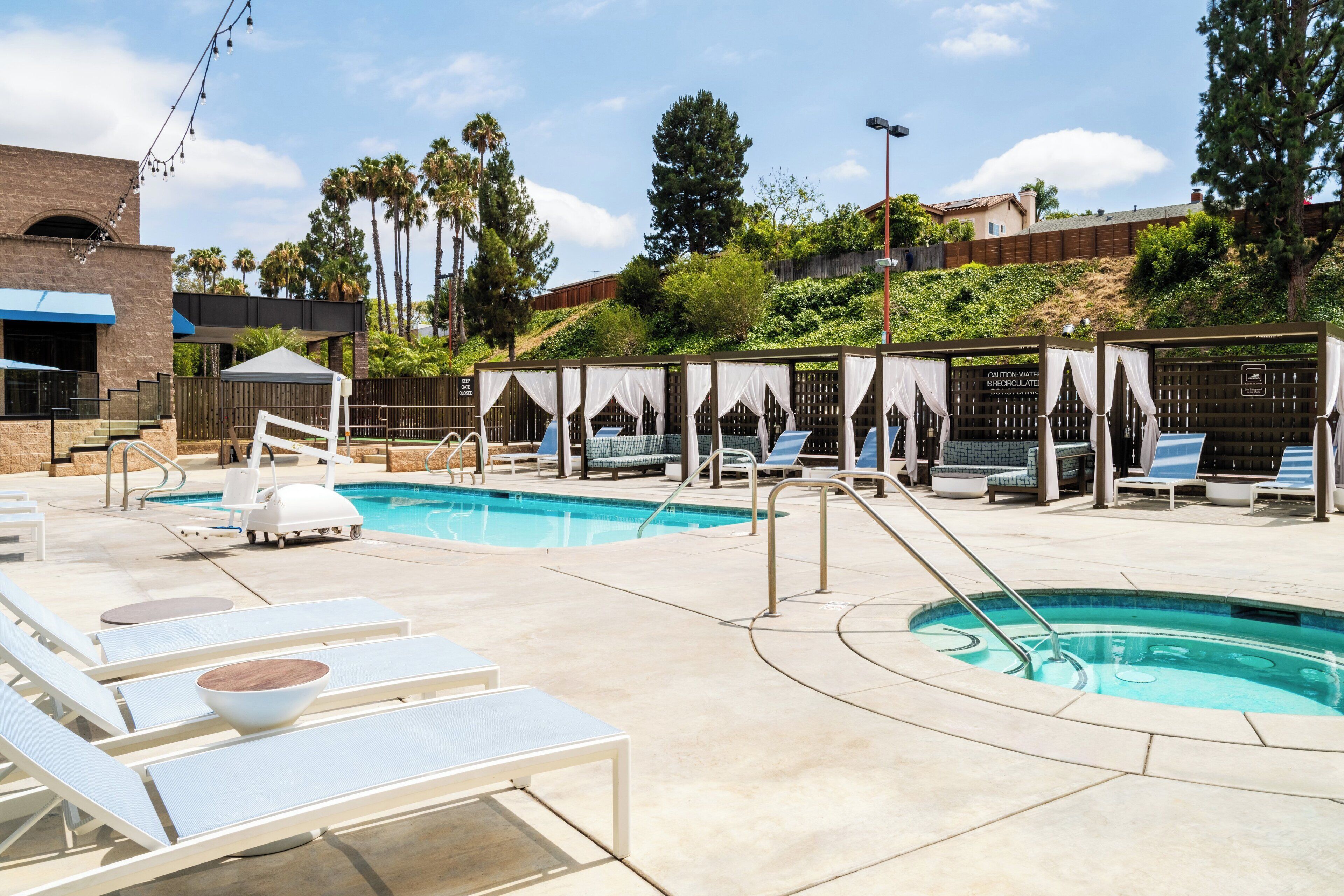 A pool area with lounge chairs, a small pool, and a covered seating area.