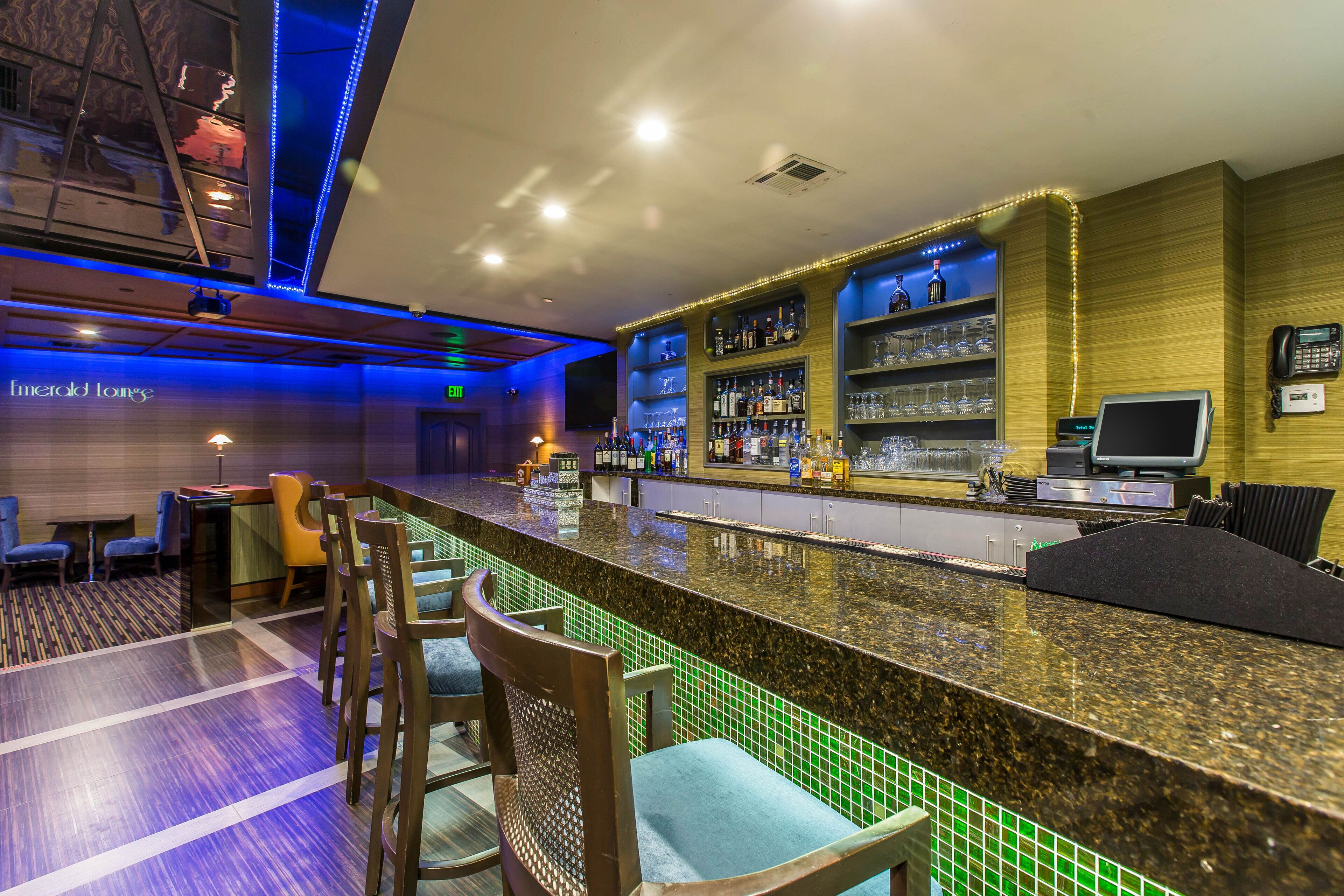 A bar area with seating and a counter, equipped with a phone and a digital display.