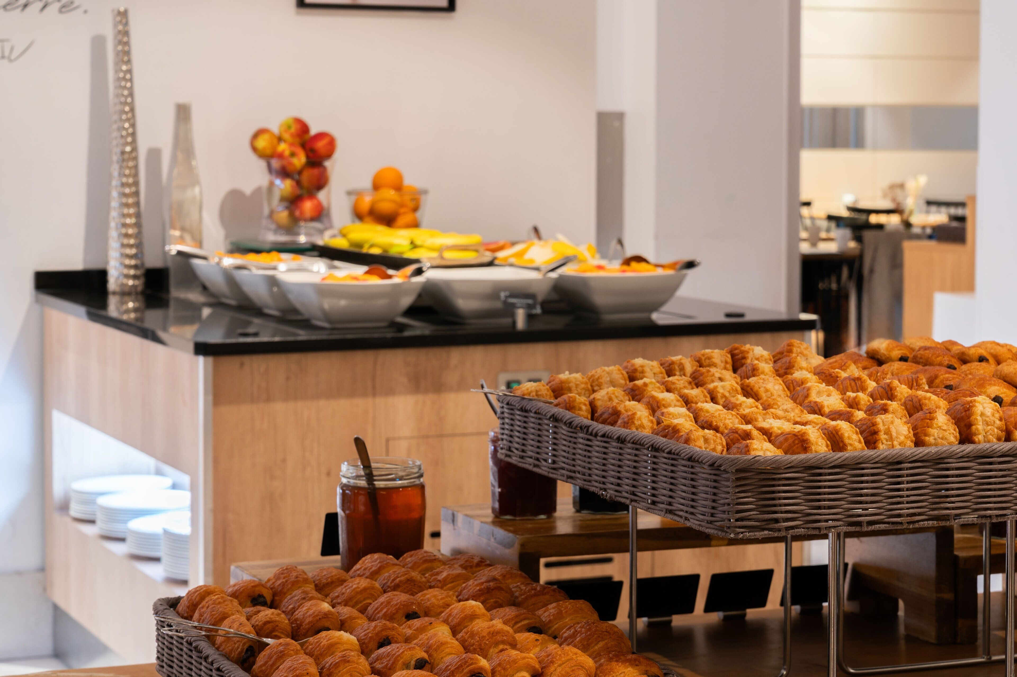 Un bufé con diferentes opciones de comida, incluyendo frutas, pasteles y bebidas.