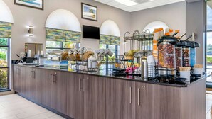 A modern coffee station with a counter, coffee machines, and a variety of coffee containers. - Comfort Inn Sun City Center - Ruskin - Tampa South (Sun City Center)