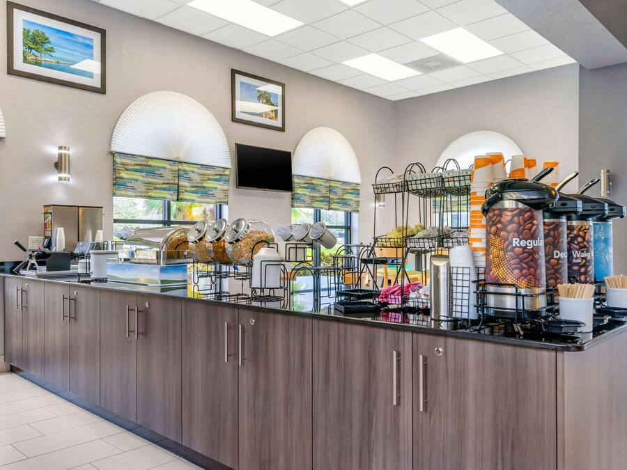 A modern coffee station with a counter, coffee machines, and a variety of coffee containers.