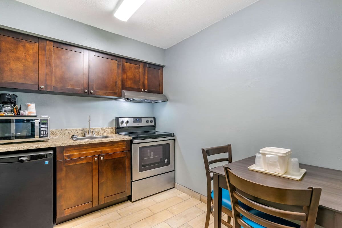 Una cocina con armarios de madera, microondas, estufa y lavavajillas.