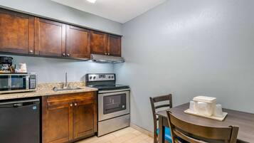 A kitchen with wooden cabinets, a microwave, a stove, and a dishwasher.