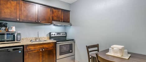 A kitchen with wooden cabinets, a microwave, a stove, and a dishwasher.