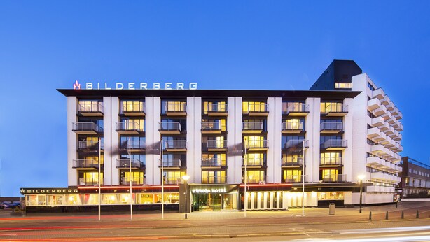 Un hôtel à plusieurs étages, doté d’une architecture moderne, de balcons et d’une enseigne bien visible.