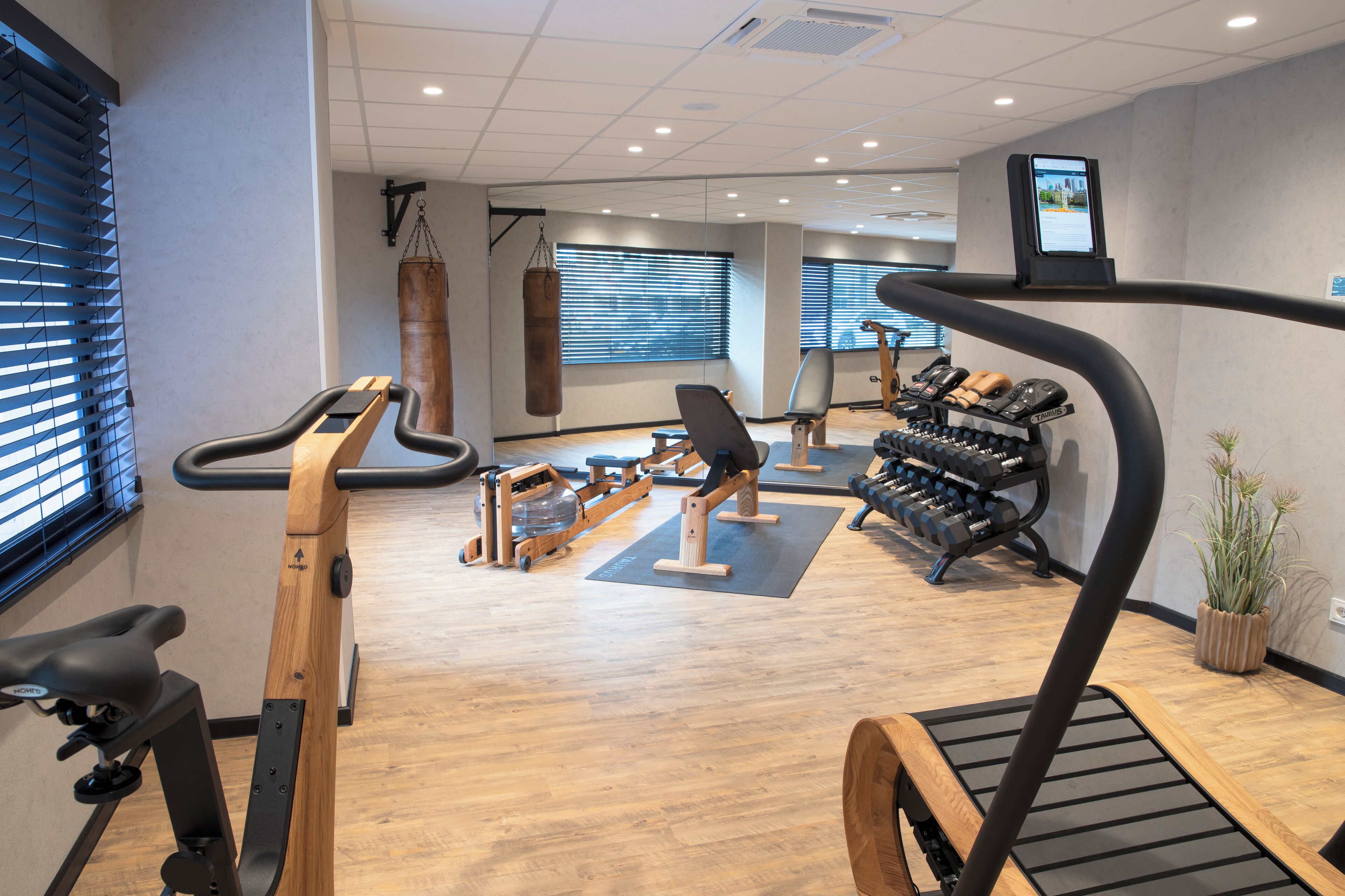 A gym with cardio machines, weight benches, and a punching bag.