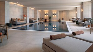 Un espace spa moderne doté d’un grand bassin aux eaux miroitantes, d’espaces de détente et d’un éclairage d’ambiance.