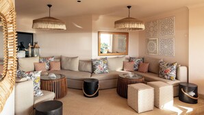 A modern living room with a sectional sofa, round coffee tables, and decorative pillows.