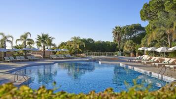 Alberca techada, alberca al aire libre y sombrillas en la alberca