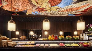 Un bufé con diferentes opciones de comida y un mural decorativo en el techo.