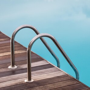 Una piscina al aire libre de temporada, tumbonas