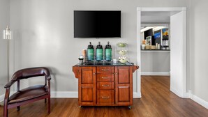 A room with a wooden cabinet, a flat-screen TV, and a coffee machine. - Quality Inn (Barbourville)