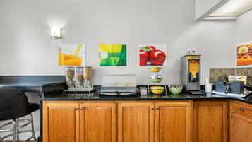 A kitchen with wooden cabinets, a black countertop, and various breakfast items.