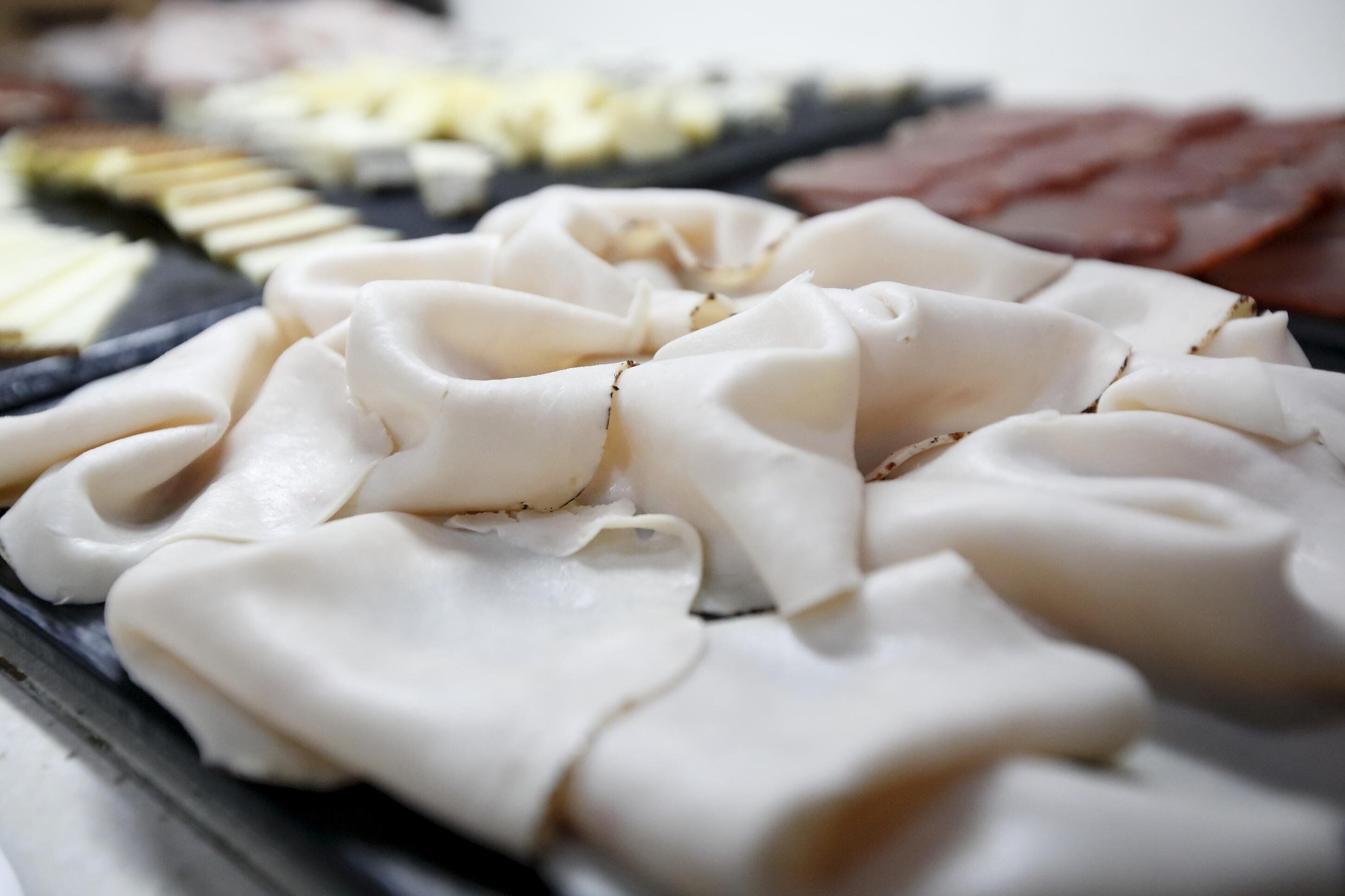 A variety of food items, including sliced meats and cheeses, arranged on a tray.