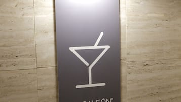 A wall-mounted sign with a martini glass icon and the text "EL GALAÓN".