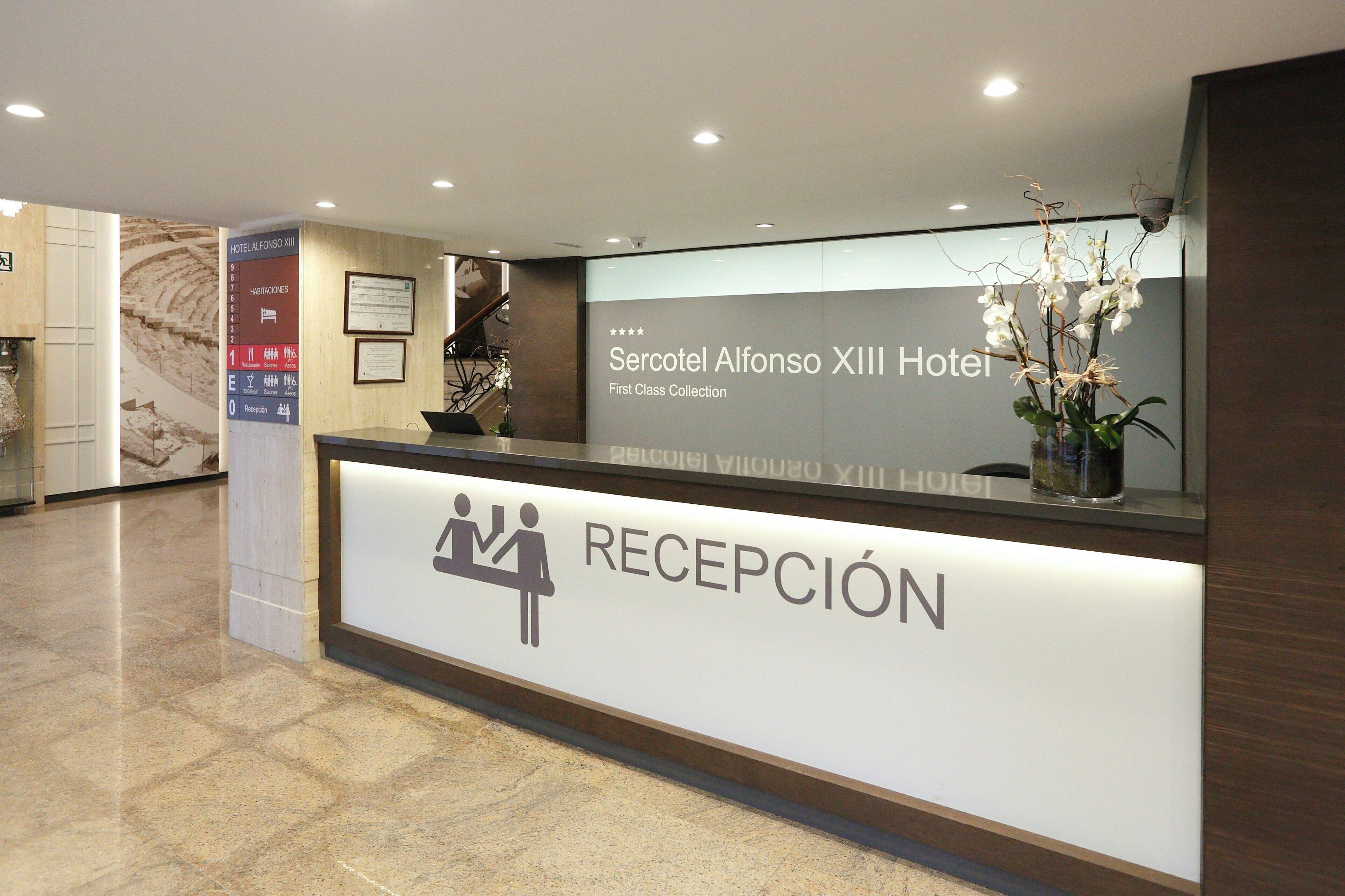 Una recepción de hotel con un letrero que indica 'Hotel Alfonso XIII' y 'First Class Collection'.