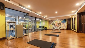 A spacious gym with wooden floors, exercise mats, and various fitness equipment. - Sarova Panafric Hotel, Nairobi Upper Hill (Nairobi)