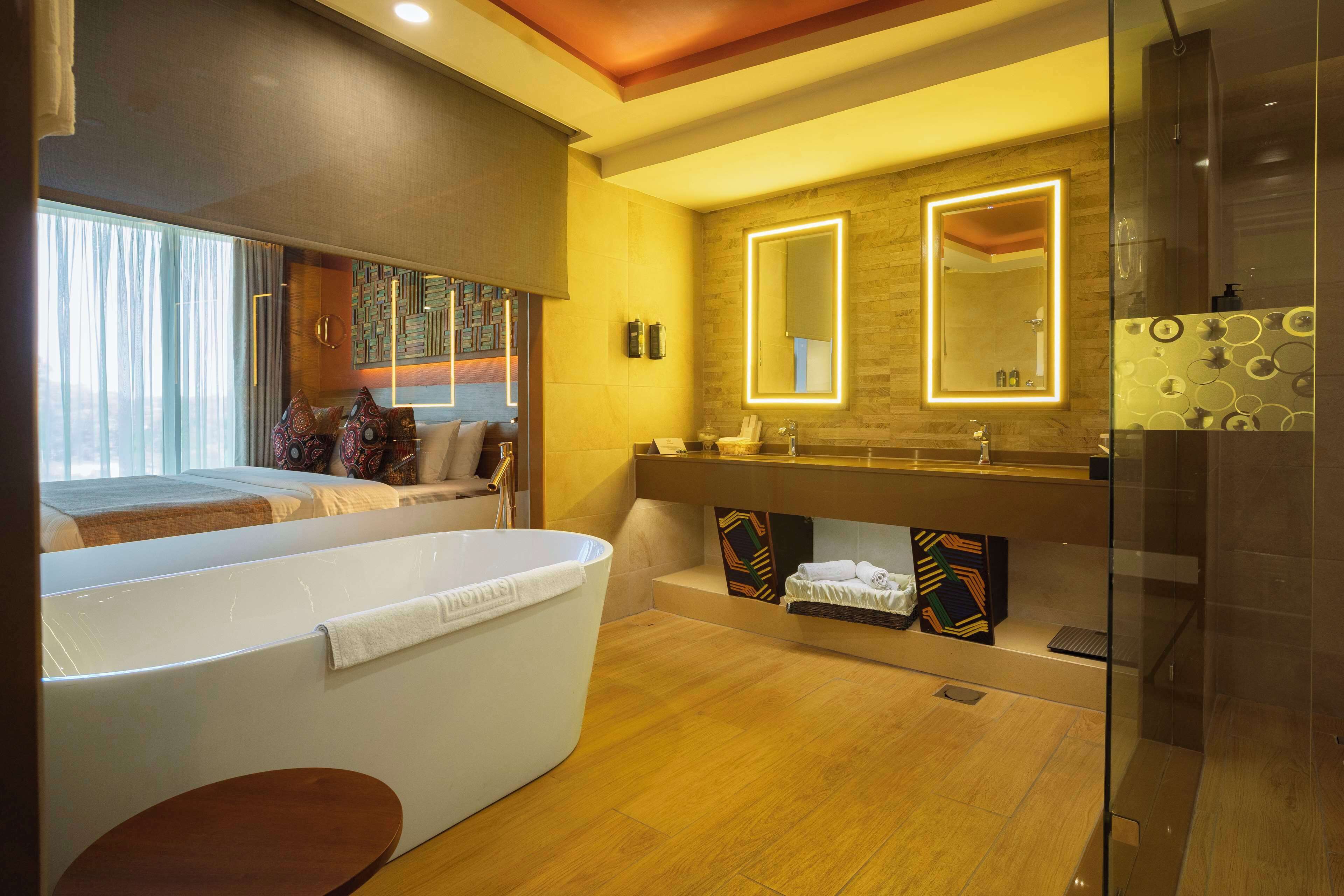 Un baño moderno con bañera, un espejo grande y zona de ducha.