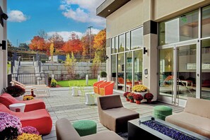 Relax on the patio surrounded by lush greenery and enjoy the serene views of the well-maintained lawn and surrounding trees.