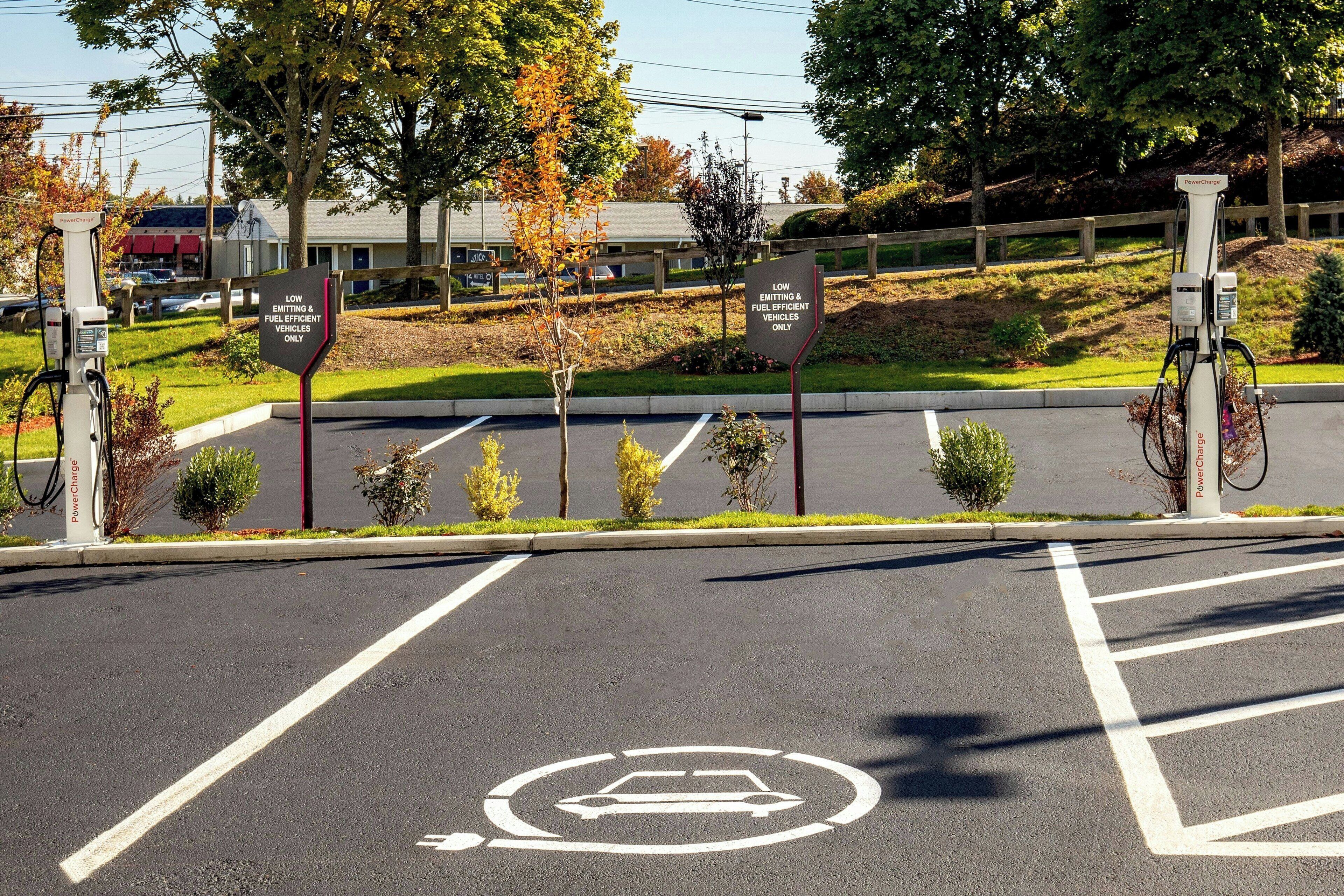 A parking area with electric vehicle charging stations and a designated parking spot for low emission vehicles.