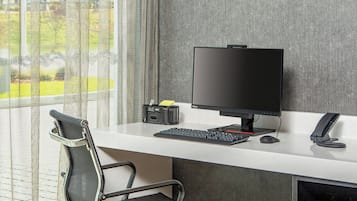 A modern office desk with a computer, keyboard, mouse, and telephone.