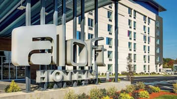 A hotel sign with the name "ELOFT HONEYVAH" and a modern building in the background.