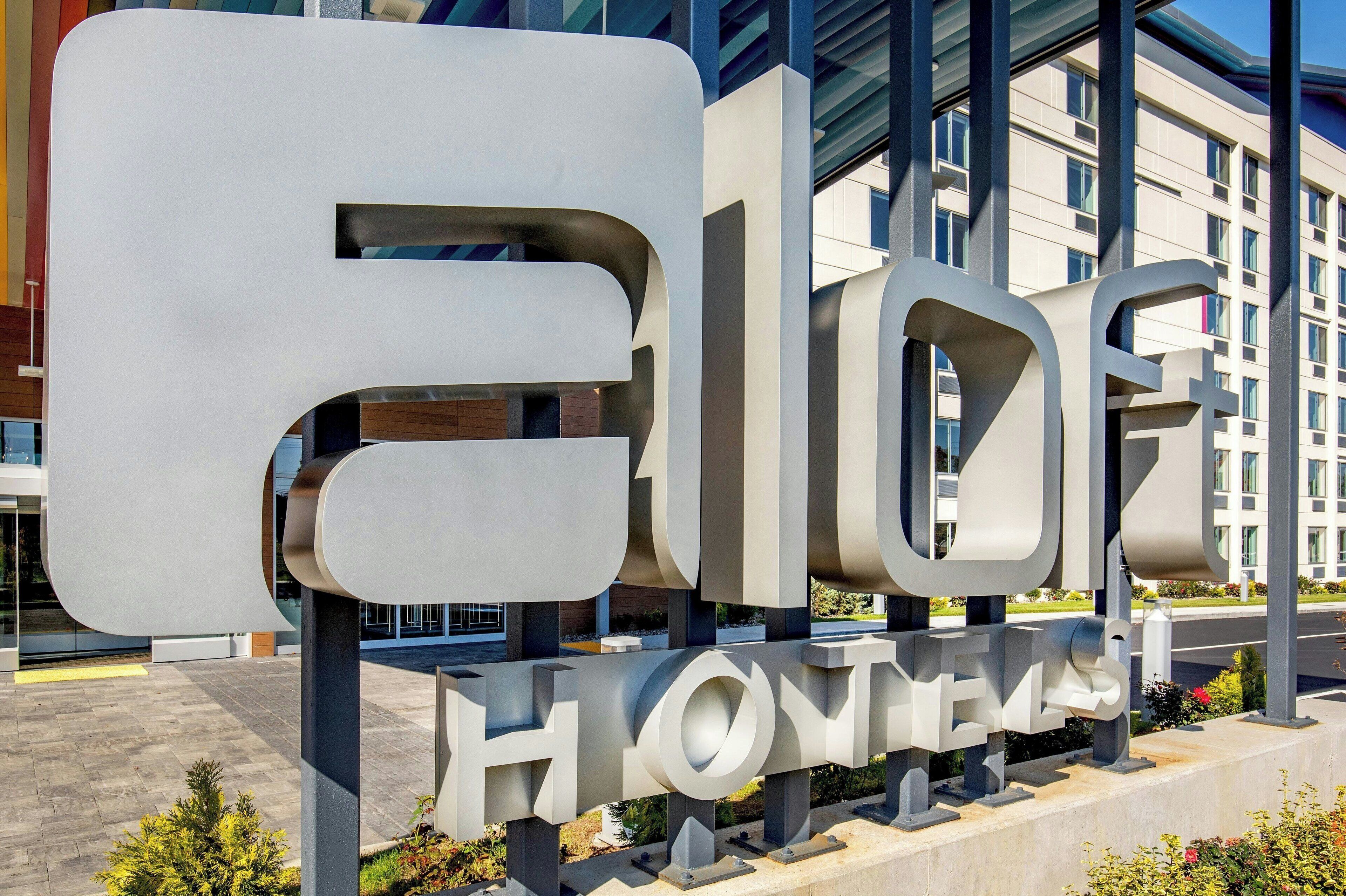 A large, modern hotel sign with the name "ELOHOMES" in bold, white letters.