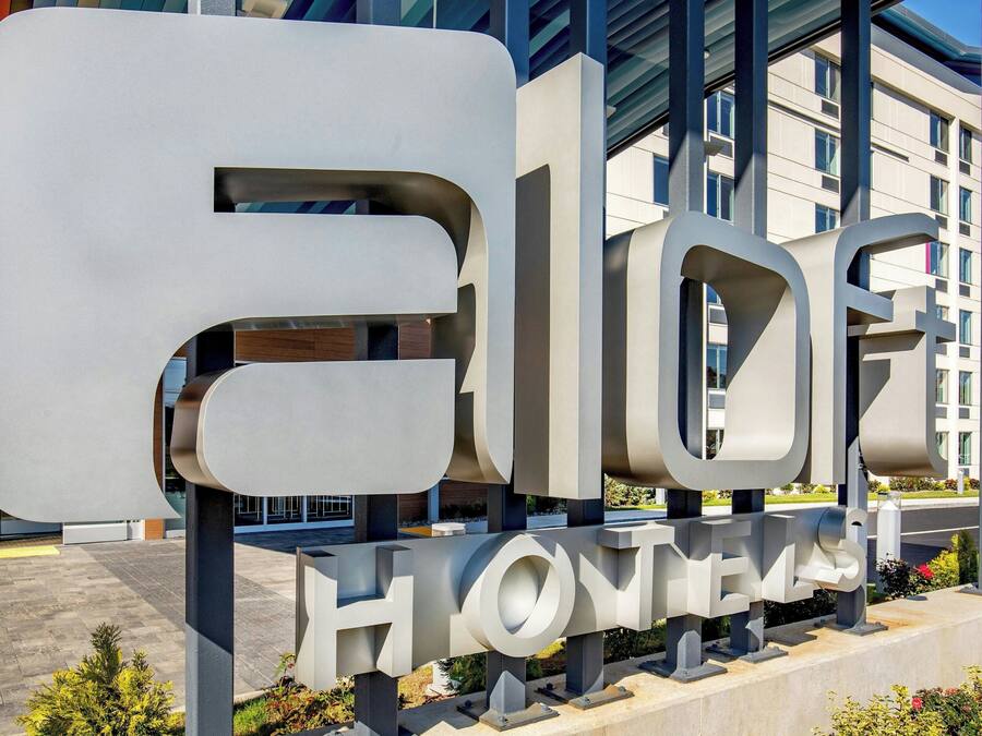 Een groot, modern hotelschilt met de naam 'ELOHOMES' in vette, witte letters.