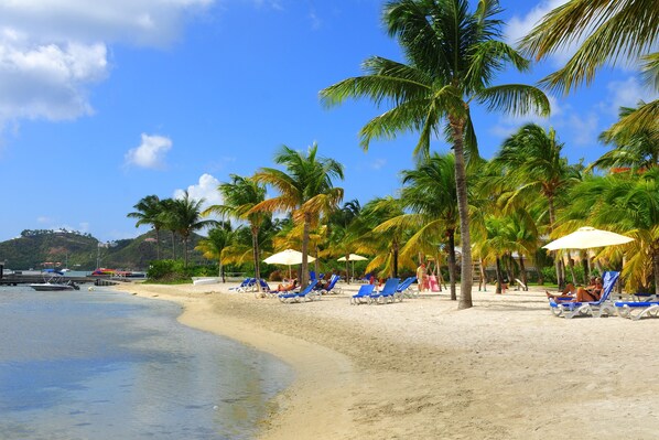Di pantai, kursi berjemur, payung pantai, dan handuk pantai