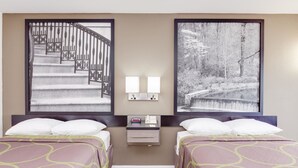 A hotel room with two beds, a nightstand with a lamp, and two framed pictures on the wall. - Super 8 by Wyndham Dalton (Dalton)