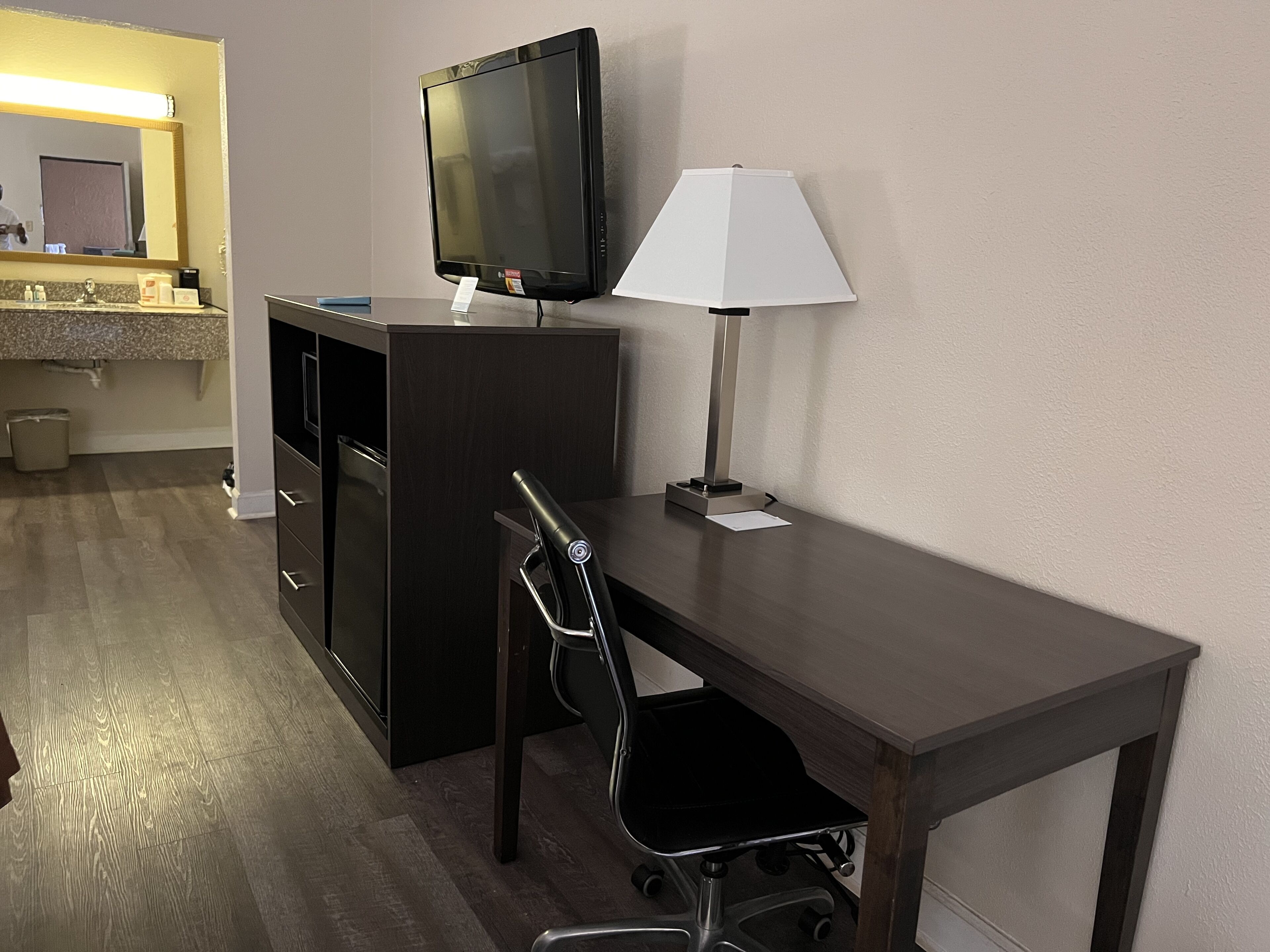 Une chambre d’hôtel équipée d’un bureau, d’une télévision, d’une lampe et d’une chaise.
