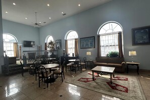 A spacious room with a dining area, seating arrangements, and large windows. - Days Inn & Suites by Wyndham Columbia Airport (West Columbia)