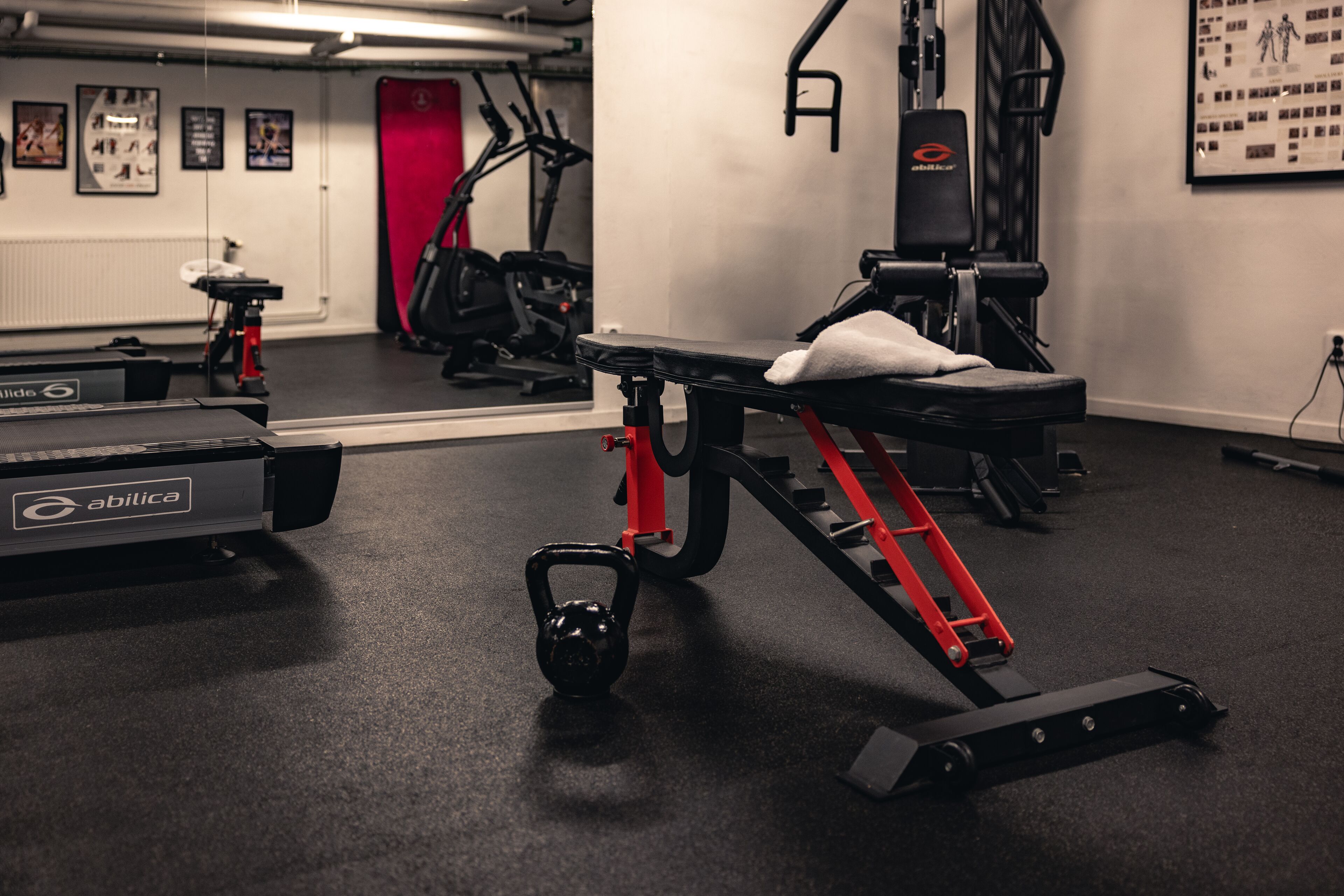 A gym with exercise equipment, including a bench and a kettlebell.