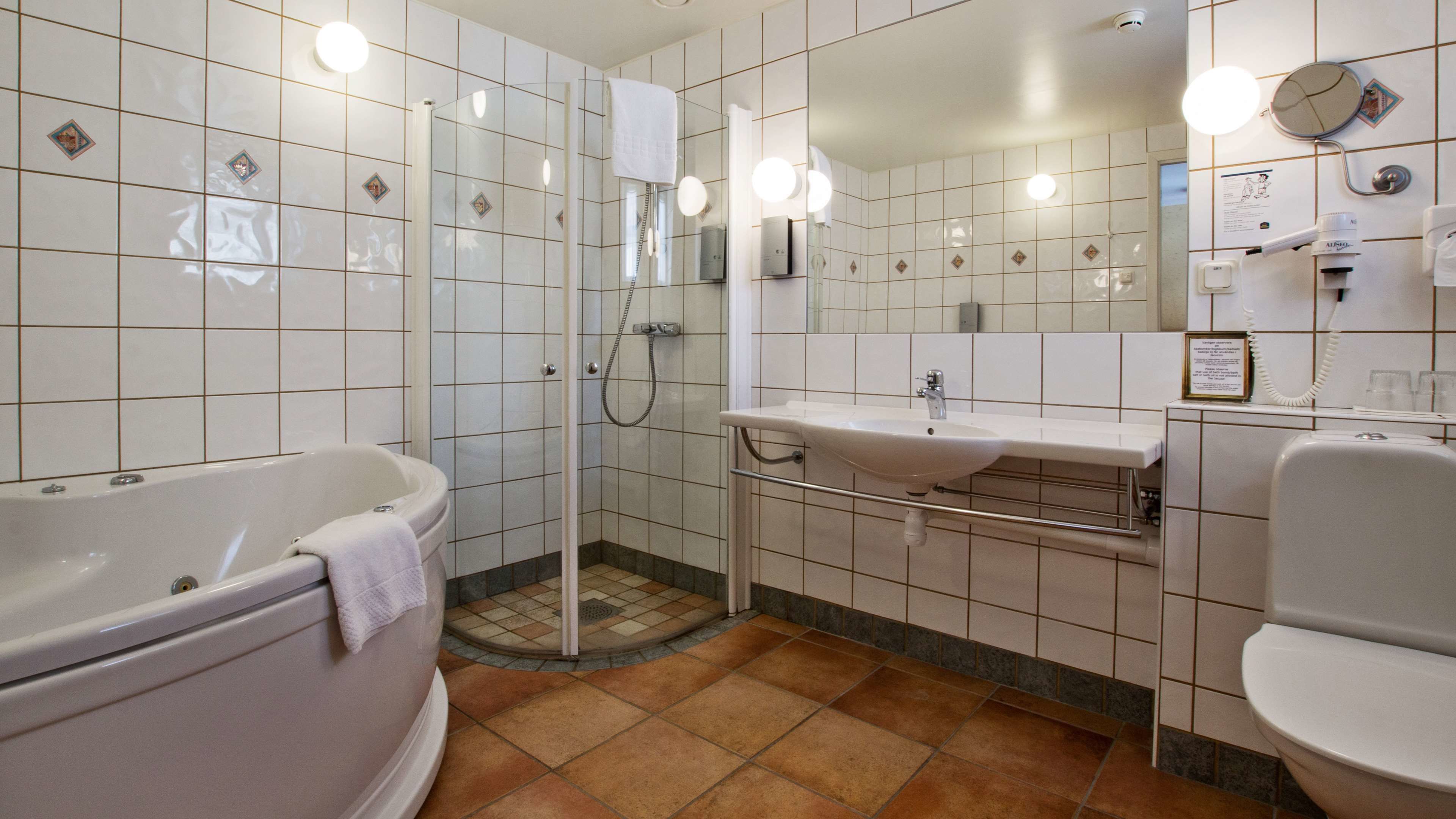 Un baño moderno con bañera, ducha y lavabo.