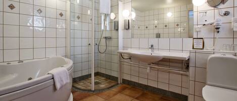 A modern bathroom with a bathtub, shower, and sink.