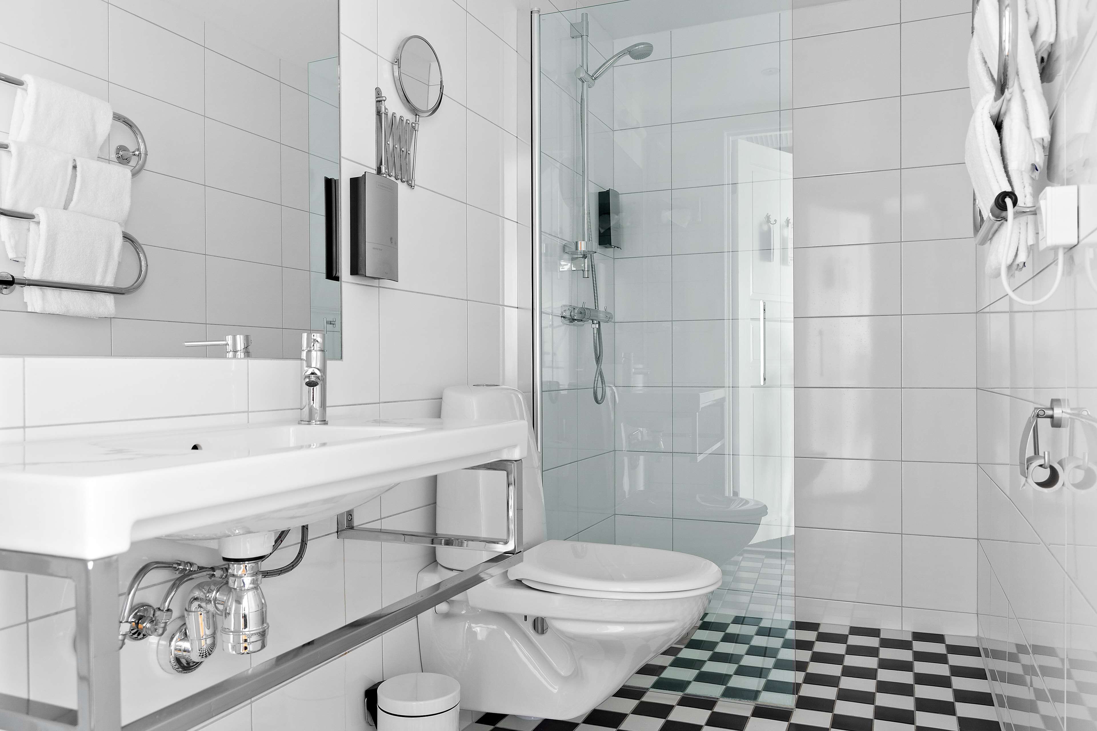 A modern bathroom with a white sink, toilet, and shower.