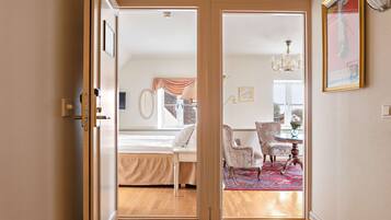 Un dormitorio con cama, una silla, una mesa y vistas al exterior.