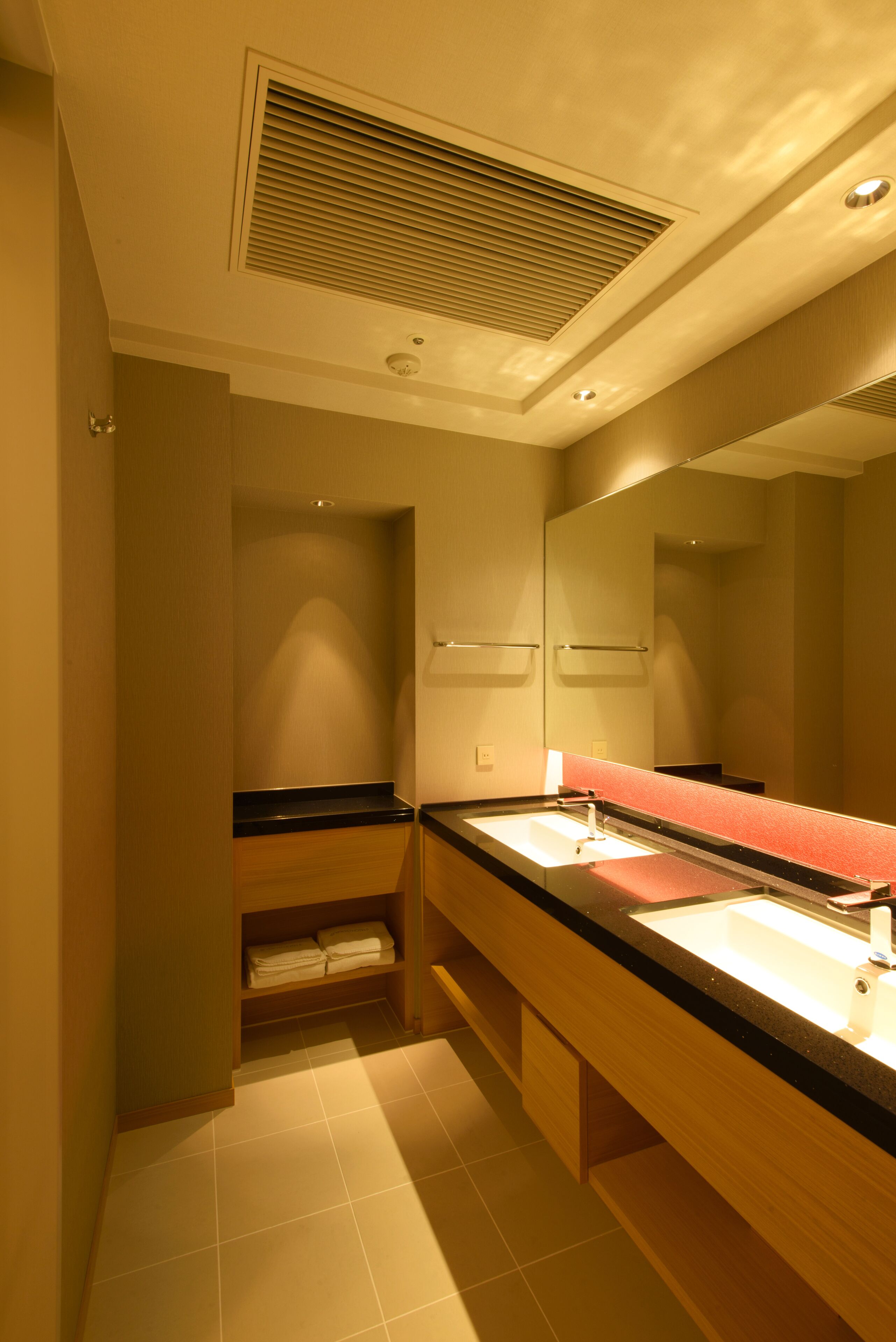 Un bagno moderno con uno specchio grande, un lavandino e un portasciugamani.