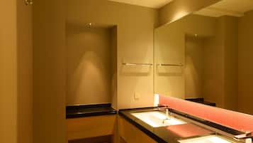 Un bagno moderno con uno specchio grande, un lavandino e un portasciugamani.