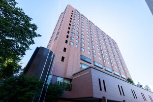 Un edificio de hotel moderno y alto con un letrero destacado que dice "Kanazawa Tokyo Hotel".