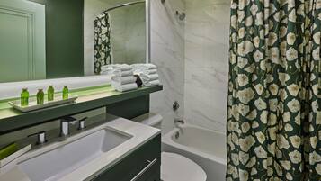 Un baño con lavamanos, espejo y zona de ducha.