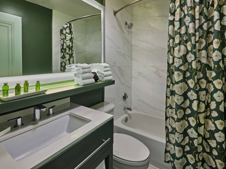 Un baño con lavamanos, espejo y zona de ducha.
