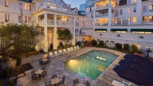 A hotel with a swimming pool, outdoor seating, and multiple balconies. - The Partridge Inn Augusta, Curio Collection by Hilton (Augusta)