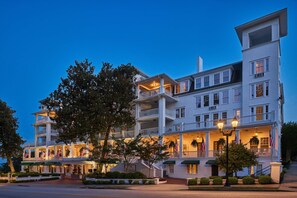 A multi-story hotel with a grand entrance, multiple balconies, and American flags displayed.