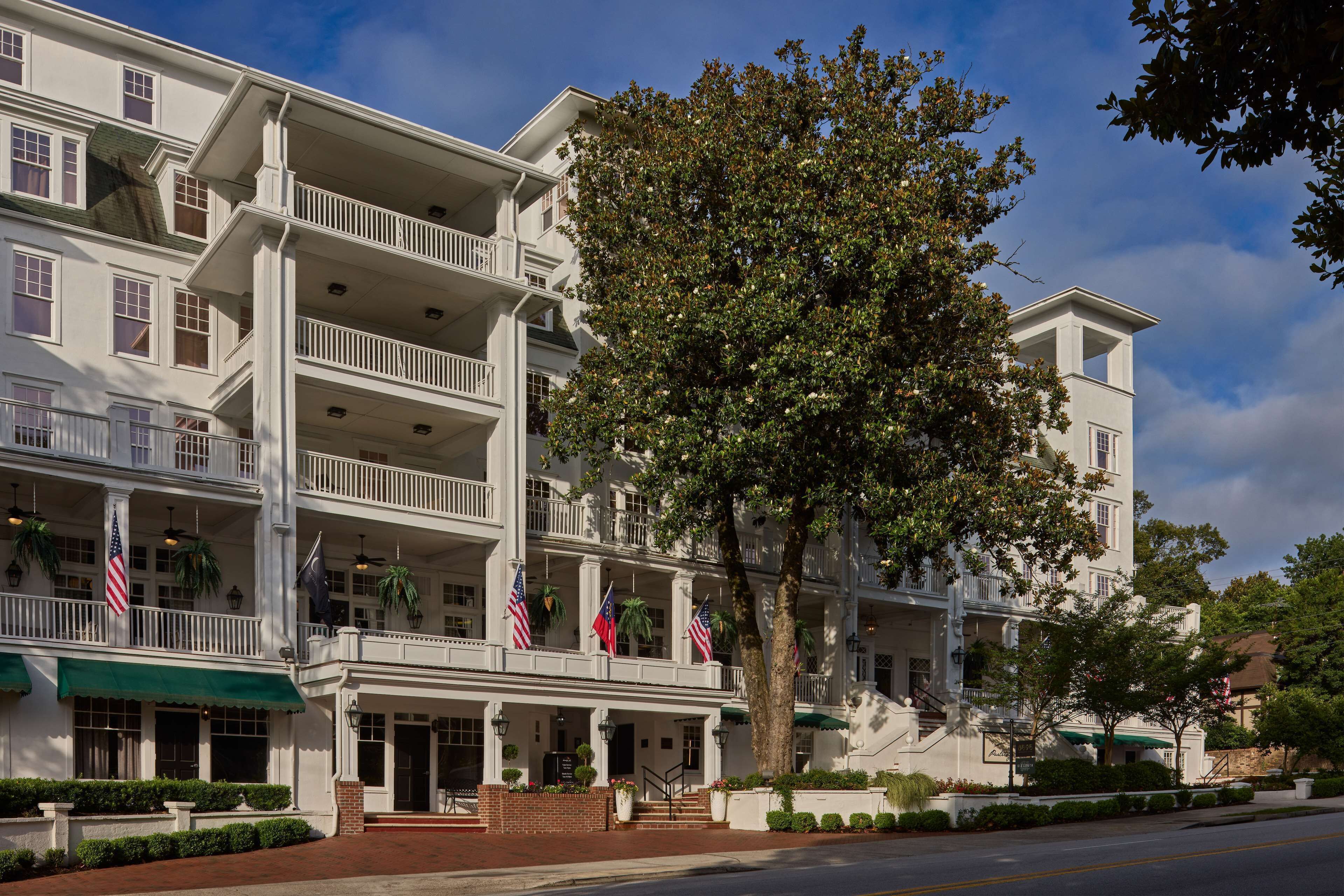 A multi-story hotel with a central courtyard, balconies, and American flags.