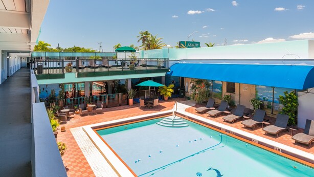 A hotel with a swimming pool, outdoor seating, and a view of the city. - Quality Inn Miami South (Miami)