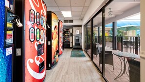 A corridor with vending machines, a reception area, and a view of the outdoor patio. - Quality Inn Miami South (Miami)